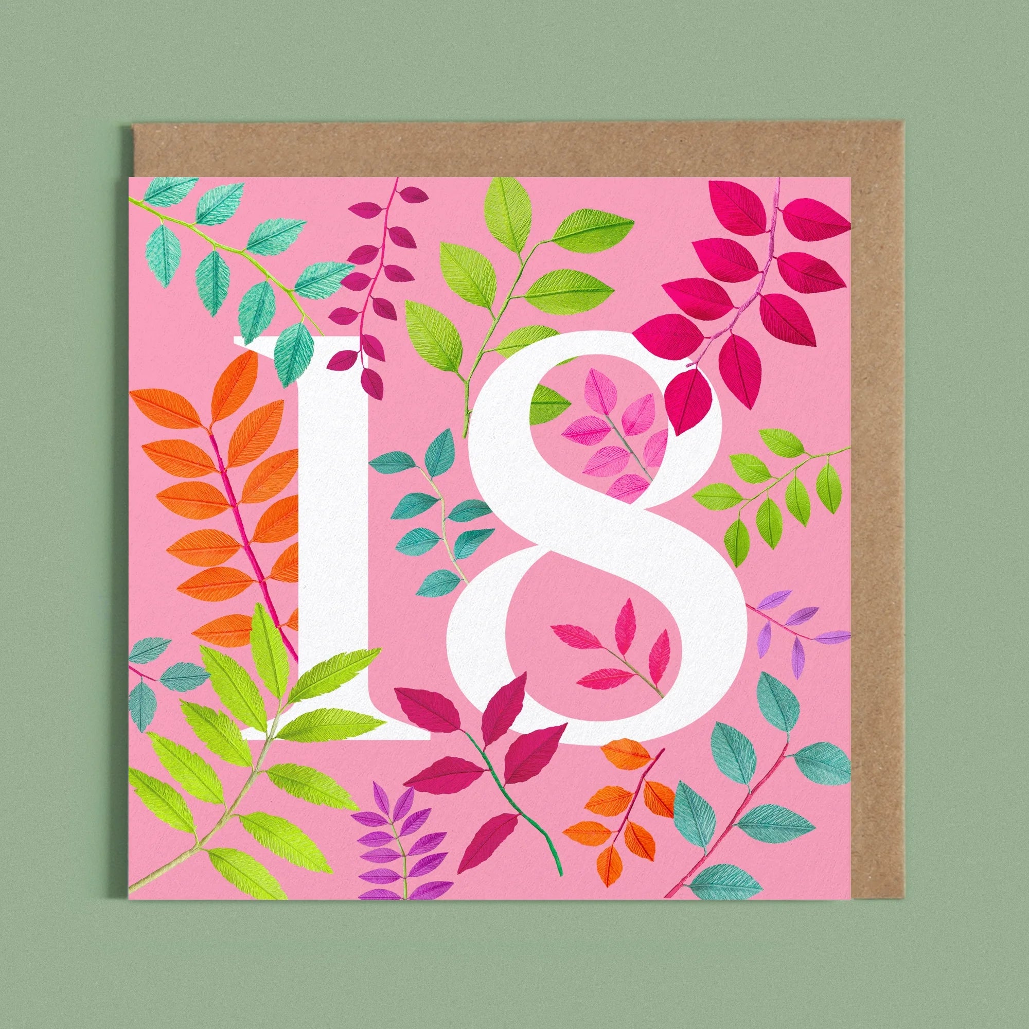 Greeting card with a image of a white number 18 and colourful handcrafted paper foliage on a pink background by paper artist Daphne Fitch.