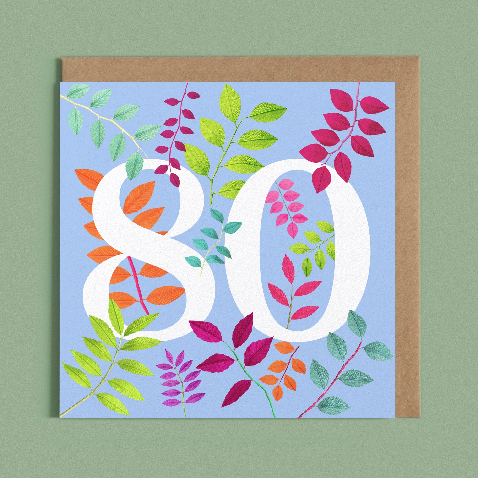 Greeting card with a image of a white number 80 and colourful handcrafted paper foliage on a blue background by paper artist Daphne Fitch.