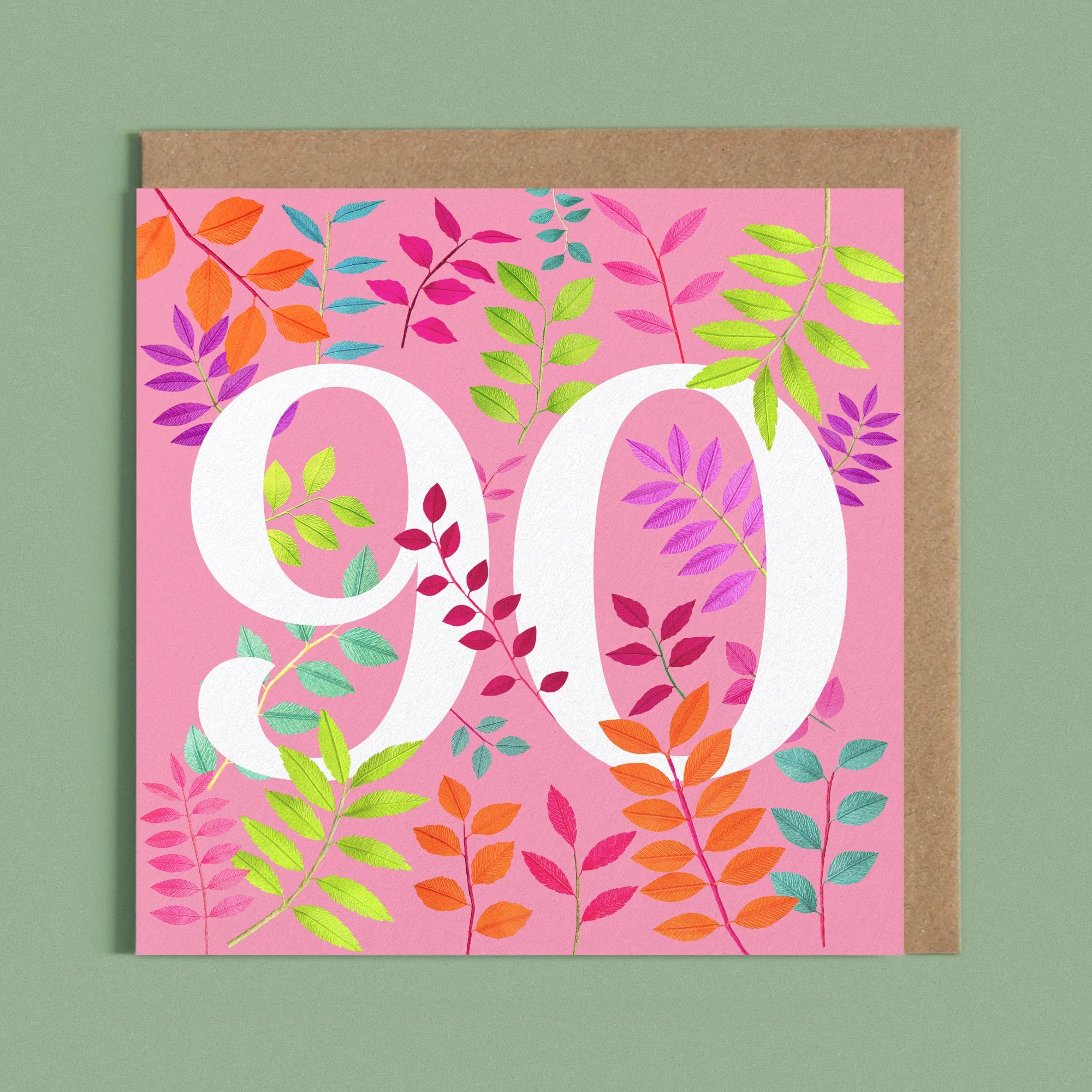 Greeting card with a image of a white number 90 and colourful handcrafted paper foliage on a pink background by paper artist Daphne Fitch.