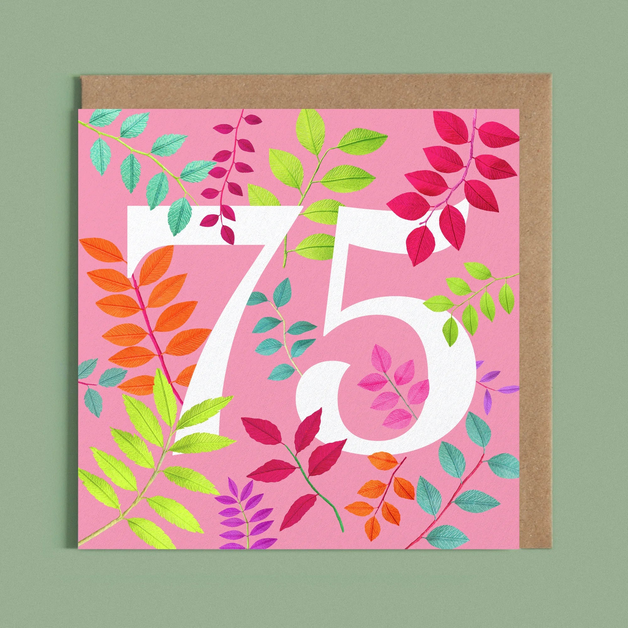 Greeting card with a image of a white number 75 and colourful handcrafted paper foliage on a pink background by paper artist Daphne Fitch.