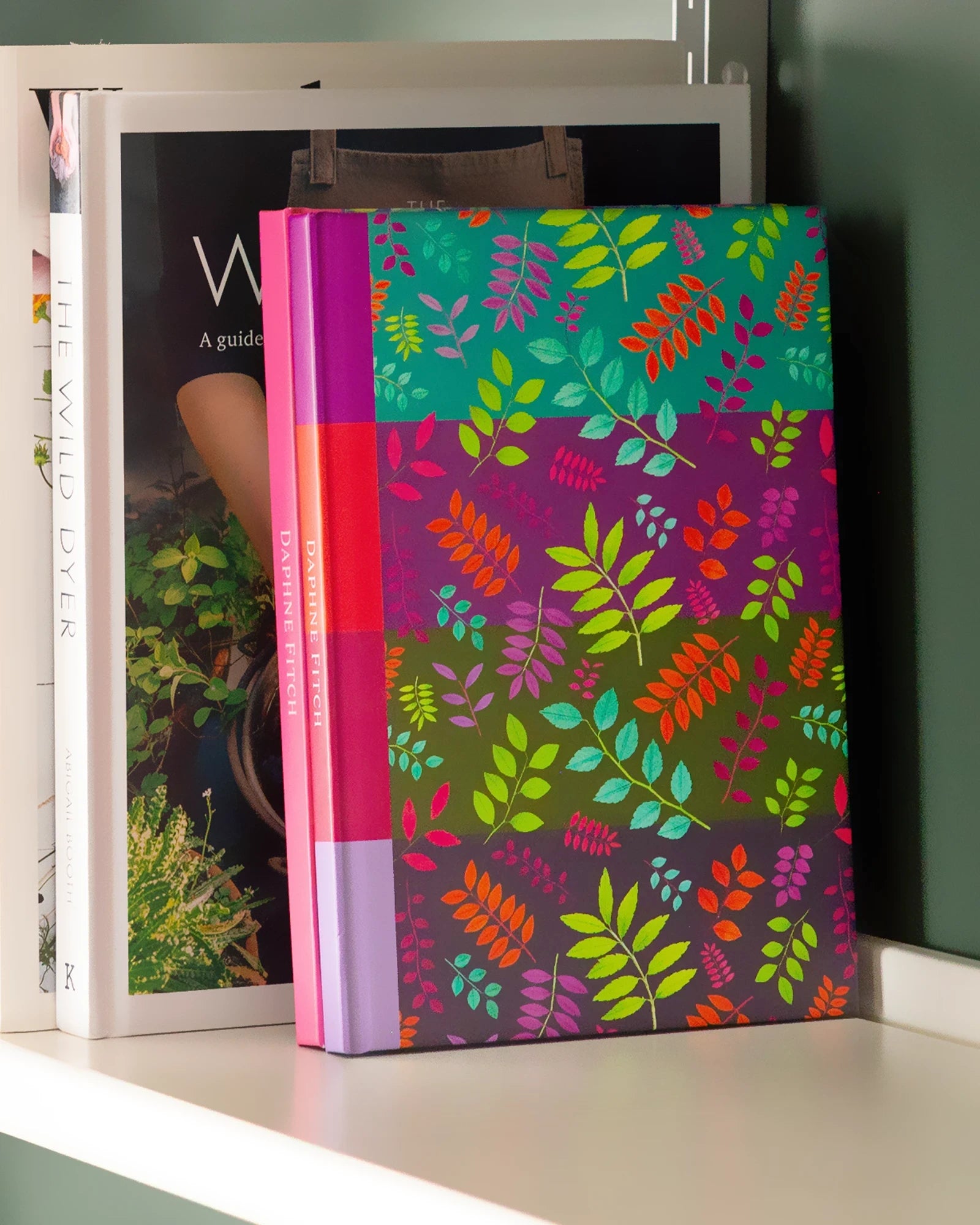 Notebook with a image of colourful handcrafted paper foliage on a striped background colour by paper artist Daphne Fitch.