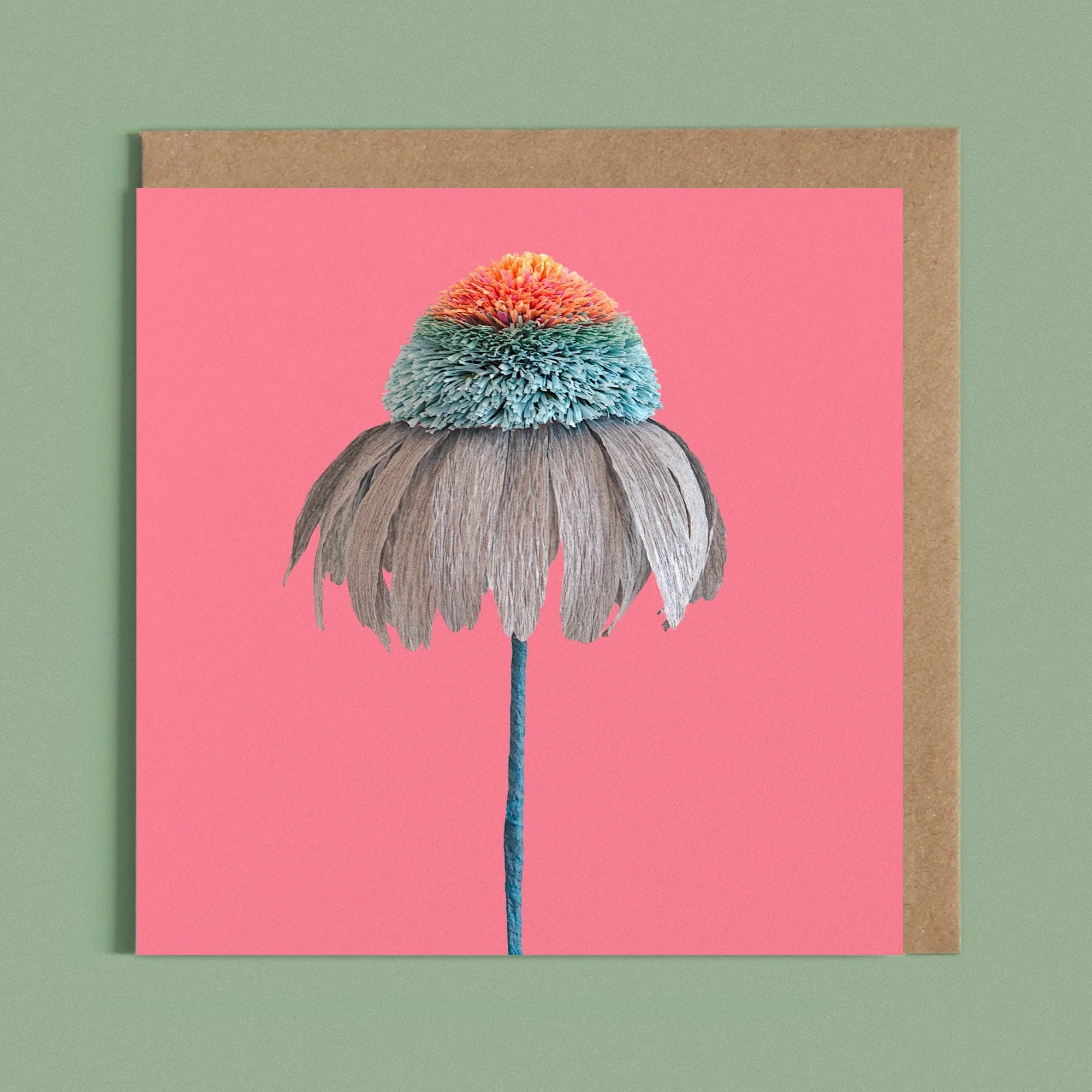 Greeting card with a image of a handcrafted paper blue and orange echinacea on a pink background by paper artist Daphne Fitch.