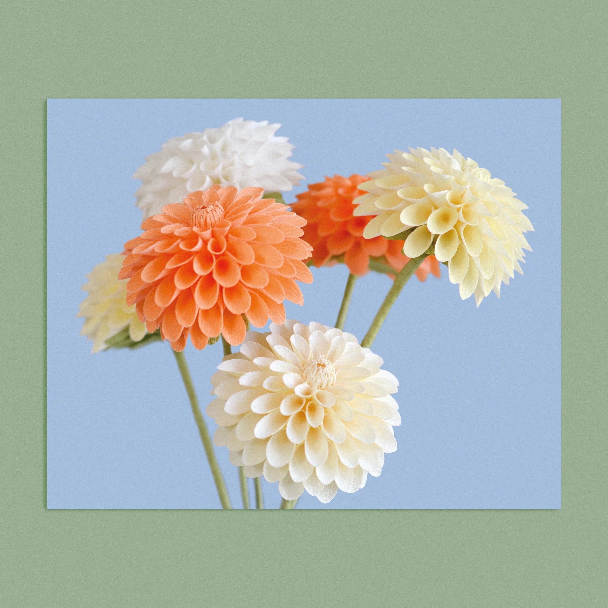 Art print with a image of a handcrafted paper cream and peach dahlia on a blue background colour by paper artist Daphne Fitch.