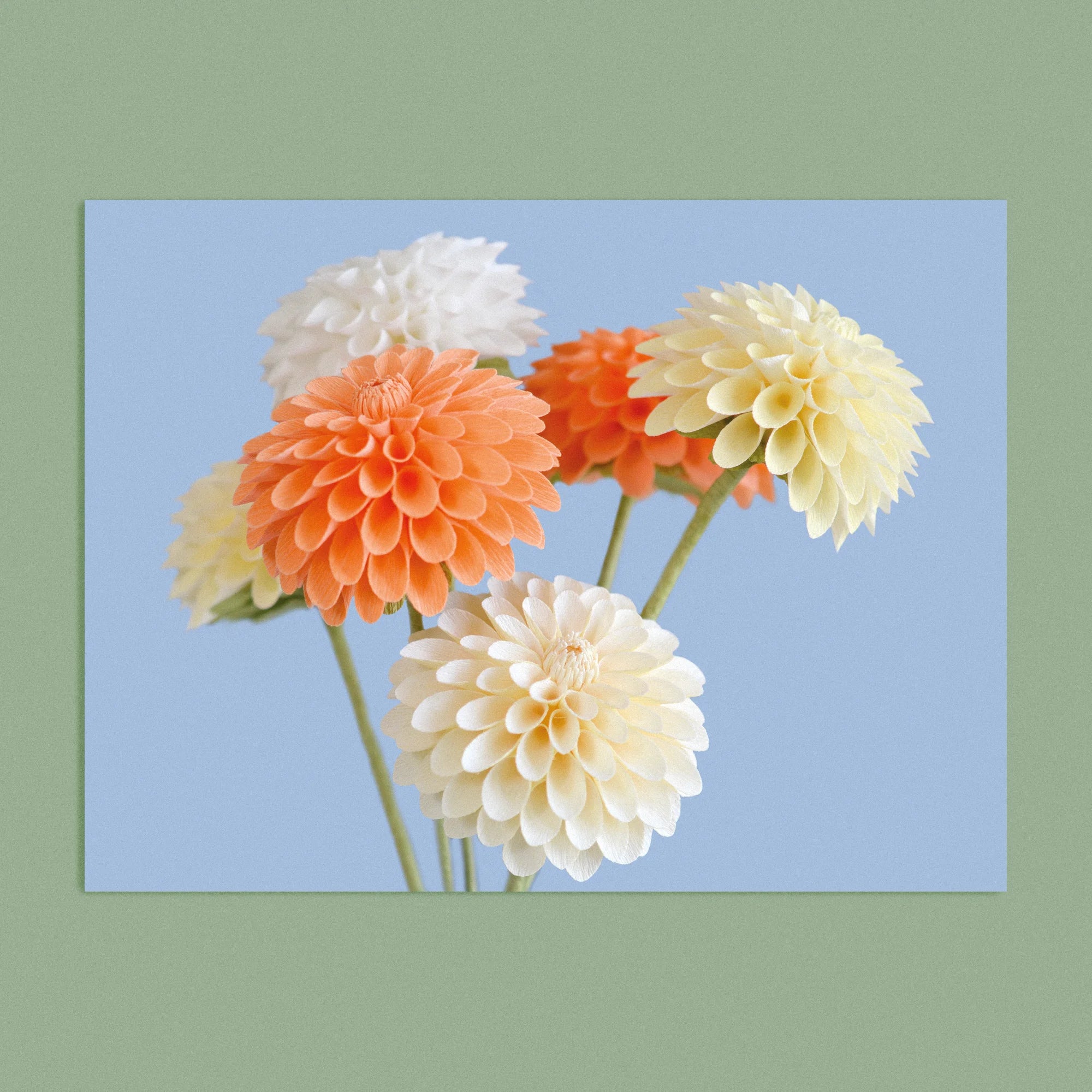 Art print with a image of a handcrafted paper cream and peach dahlia on a blue background colour by paper artist Daphne Fitch.