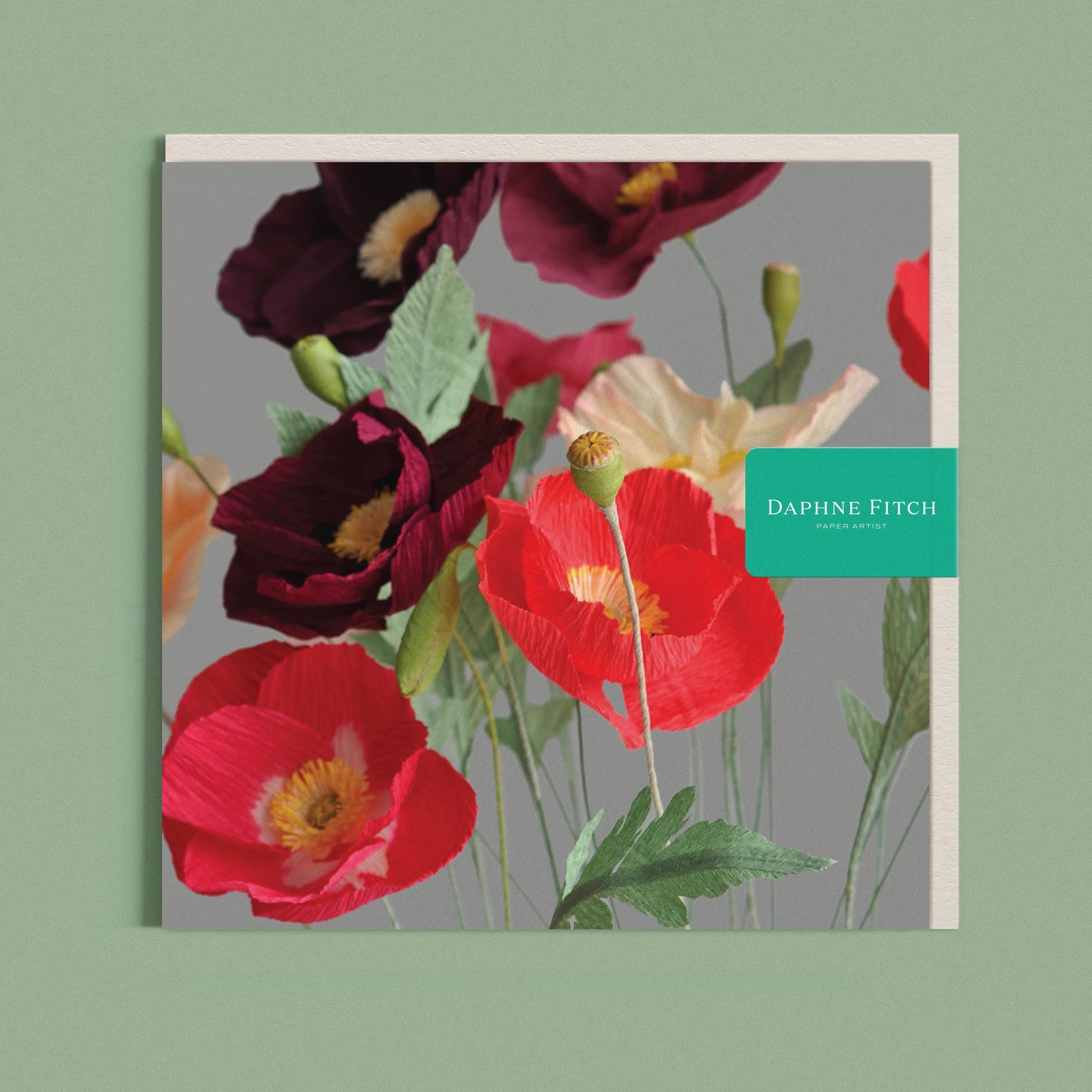 Greeting card with a image of a handcrafted paper poppies on a grey background by paper artist Daphne Fitch.