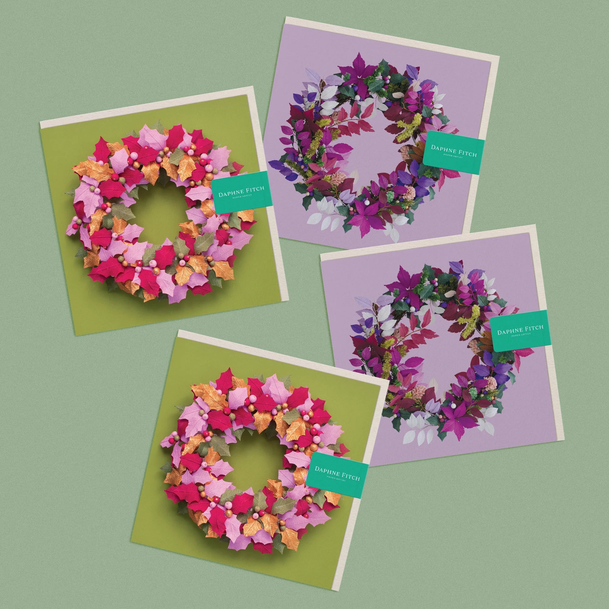 Set of 4 greeting cards, with images of a handcrafted paper festive wreaths on green and purple backgrounds by paper artist Daphne Fitch.