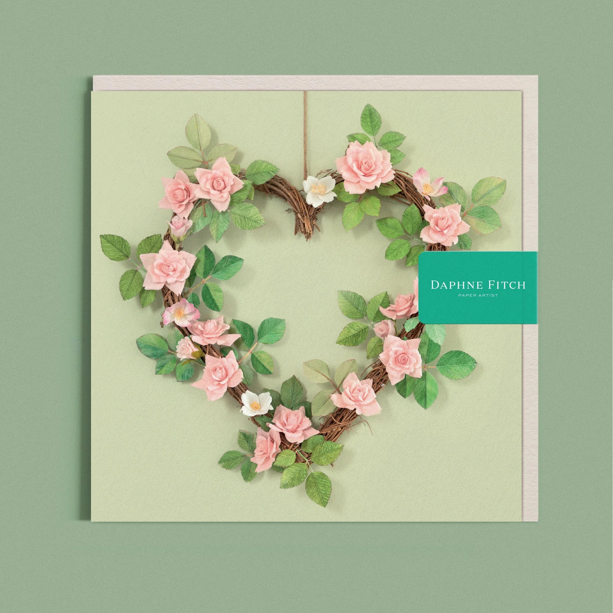Greeting card with a image of a romantic handcrafted paper rose wreath on a light green background by paper artist Daphne Fitch.